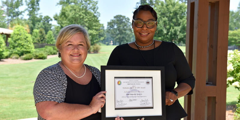 Alabama DHR Deputy Commissioner Karen Smith presents the 2021 Spirit of APS Award to Adrine Smith-Brown at the Adult Protective Services Legal Conference in Opelika.